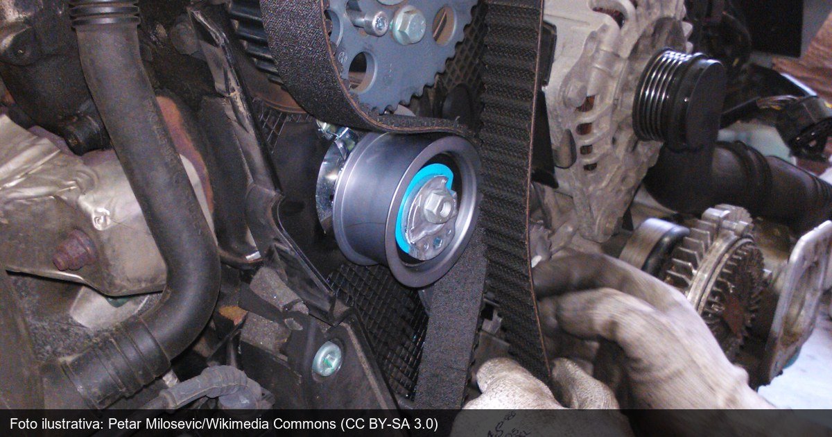 Mecânico realizando a troca de correia dentada no motor de um carro